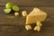 Radamer cheese on a wooden board served with lime. triangular piece of yellow cow`s milk swiss cheese with holes