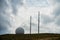 Radar in a sphere and big antena on the top of the mountain on cloudy sky background