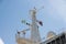 Radars lanterns and flags on the top mast of a ferry..