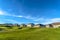 Radiant blue sky and clouds over houses and golf course on a sunny day