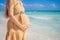 Radiant and expecting, a pregnant woman stands on a pristine snow-white tropical beach, celebrating the miracle of life