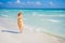 Radiant and expecting, a pregnant woman stands on a pristine snow-white tropical beach, celebrating the miracle of life