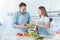 Radiant father and female child making salad together