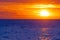 Radiant orange sunset over blue wavy sea