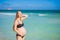 Radiant pregnant woman in a swimsuit, amid the stunning backdrop of a turquoise sea. Serene beauty of maternity by the