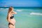 Radiant pregnant woman in a swimsuit, amid the stunning backdrop of a turquoise sea. Serene beauty of maternity by the