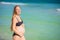 Radiant pregnant woman in a swimsuit, amid the stunning backdrop of a turquoise sea. Serene beauty of maternity by the