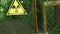 A radiation sign on an old iron gate fastened with a chain and a lock. Warning about the danger