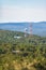 Radio cell towers in a hilly mountainous area surrounded by forest.