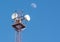 Radio cellular antenna over blue sky and big half moon