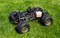 Radio-controlled car with internal combustion engine for nitro fuel, with one cylinder, standing on green grass.