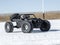 Radio controlled car models: a small black buggy toy with dirty splashes stands in the snow.