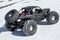 Radio controlled car models: a small black buggy toy with dirty splashes stands in the snow.