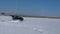 Radio-controlled car: a small black buggy model rushing at a crazy speed in the fresh snow.
