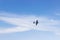 Radio controlled toy airplane against blue sky with white clouds