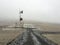 Radio station in snow. Empty road in front of a mountain range w