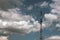 Radio tower antenna on a background of blue sky with white clouds. Telecommunication transmitter global telephone equipment