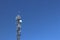 Radio tower with antennas on a blue sky background. Metal construction. Wireless tezhnologii. Transmission of a tele-radio signal.