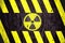 Radioactive ionizing radiation danger symbol with yellow and black stripes painted on a massive concrete wall