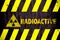 Radioactive ionizing radiation or nuclear energy danger symbol word yellow hazard black stripes painted on concrete