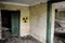 Radioactive warning sign on the grunge dirty wall in abandoned building from the exclusion zone. Chernobyl Pripyat atmosphere