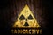 Radioactive: yellow radioactive ionizing radiation danger symbol with word radioactive painted below the sign