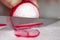 A radish being clipped thinly bu the chef on a cutting board