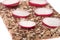 Radish on crispy bread. Stack of wholegrain crispy bread with sunflower, chia and sesames seeds on white background.