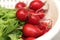 Radishes being washed in the sink in a colander