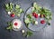 Radishes with green haulm leaves an grain cheese on dark rustic background, top view