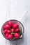 Radishes in white saucepan