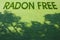 Radon free: land free from the natural dangerous radioactive gas that comes from the earth - concept image with text over a green