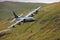 RAF Royal Air Force Lockheed C-130 Hercules transport plane carrying out low level flying in the United Kingdom