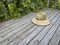 raffia straw sun hat on a wooden backyard deck