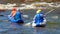 Rafting, kayaking. Athletes in sports equipment are sailing on a rubber inflatable boat in a boiling water stream.