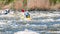 Rafting, kayaking. Close-up view of oars with splashing water. A man in a small kayak in a stormy stream of water.