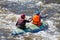 Rafting, kayaking. Two sportsmen in sports equipment are sailing on a rubber inflatable boat in a boiling water stream.