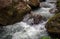 Rafting river among black rocks. Fresh water fast stream in stones.