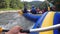 Rafting on Rough Mountain River. Adventure Team in Rubber Boat Goes Down Stream