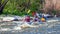 Rafting. Three sportsmen are sailing on a rubber inflatable boat. Teamwork. Water splashes close-up. Ecological tourism