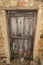 Ragged brown wooden door in a stone wall close-up of village house. Italy .