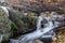 Raging mountain river. Mountain landscape in autumn. Course of the river with stones. Water and vegetation of the sierra.