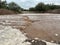 Raging river from flash flood on rural road in Arizona