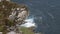 Raging waves seen from above a cliff with vegetation