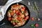 Ragout of rabbit in Mediterranean style with vegetables and herbs in a frying pan.