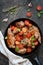 Ragout of rabbit in Mediterranean style with vegetables and herbs in a frying pan.