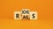 Rags or riches symbol. Concept word Rags Riches on wooden cubes. Beautiful orange table orange background. Business and rags or