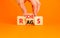 Rags or riches symbol. Concept word Rags Riches on wooden cubes. Beautiful orange table orange background. Businessman hand.