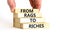 Rags or riches symbol. Concept words From rags to riches on wooden blocks. Beautiful white table white background. Businessman