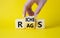 Rags vs Riches symbol. Businessman hand turns wooden cubes and changes the word Rags to Riches. Beautiful yellow background. Rags